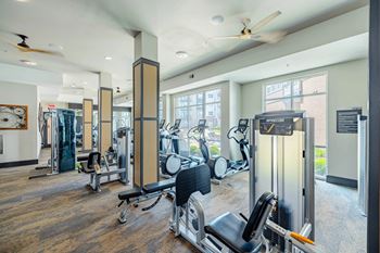 A gym with a variety of equipment including treadmills, weights, and exercise machines. at Bridge at Henley, Texas